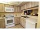 Bright kitchen features white appliances and wood cabinets at 8 Escondido Cir # 79, Altamonte Springs, FL 32701