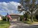 One-story house with attached garage, American flag, and landscaped yard at 217 Anastasia Dr, Kissimmee, FL 34759