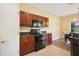 Kitchen features dark wood cabinets, black appliances, granite countertops, and tile floor at 217 Anastasia Dr, Kissimmee, FL 34759