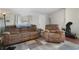 Living room with brown reclining sofa and chair, wood floors, and a ceiling fan at 1020 Wisconsin Ave, St Cloud, FL 34769