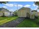 Brick pathway leads to a storage shed in the backyard, with a small house and grassy area at 1020 Wisconsin Ave, St Cloud, FL 34769