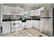 White kitchen with stainless steel appliances and granite countertops at 1020 Wisconsin Ave, St Cloud, FL 34769