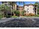 Exterior view of a condo building with parking and landscaping at 9055 Treasure Trove Ln # 206, Kissimmee, FL 34747