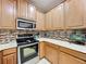 Bright kitchen featuring stainless steel appliances and wood cabinetry at 452 Harbor Winds Ct, Winter Springs, FL 32708