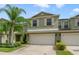 Two-story townhome with light green exterior, two-car garage, and landscaping at 3349 Rodrick Cir, Orlando, FL 32824