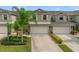 Two-story townhome with light green exterior, two-car garage, and landscaping at 3349 Rodrick Cir, Orlando, FL 32824