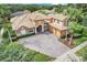 An aerial view showcasing a grand house with a tile roof, expansive driveway, and mature landscaping at 9106 Panzani Pl, Windermere, FL 34786