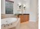 Elegant bathroom with a soaking tub, double vanity, and granite countertop at 9106 Panzani Pl, Windermere, FL 34786