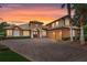 Two-story house with brick driveway and palm trees at dusk at 9106 Panzani Pl, Windermere, FL 34786