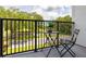 Private balcony with table and chairs, overlooking a tree-lined street at 2120 Broome St, Kissimmee, FL 34743