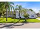 One-story home with white exterior, lush lawn, and palm trees at 148 Merida Dr, Kissimmee, FL 34743