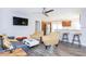 Modern living room with gray sofa and yellow armchairs, hardwood floors, and kitchen views at 631 Trailwood Dr, Altamonte Springs, FL 32714