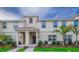 Two-story townhome with front porch, landscaping, and palm trees at 4804 Memories Ln, Kissimmee, FL 34746