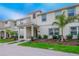 Two-story townhome with front porch, landscaping, and palm trees at 4804 Memories Ln, Kissimmee, FL 34746