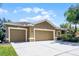 Tan two-car garage house with a landscaped yard at 2134 Osprey Woods Cir, Orlando, FL 32820