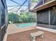 Relaxing pool area with stone bench and screened enclosure at 1469 Grace Lake Cir, Longwood, FL 32750