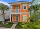 Front view of a two-story orange house with balcony and green shutters at 8027 Knee Deep Rd, Kissimmee, FL 34747