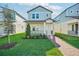 Two-story light blue house with brick walkway, landscaping, and a front porch at 11960 Bracco St, Winter Garden, FL 34787
