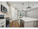 Modern kitchen with white cabinets, stainless steel appliances, and quartz countertops at 11960 Bracco St, Winter Garden, FL 34787