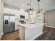Modern kitchen with white cabinets, stainless steel appliances, and quartz countertops at 11960 Bracco St, Winter Garden, FL 34787