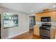 Kitchen with wood cabinets, black appliances, and hardwood floors at 5625 Chipola Cir, Orlando, FL 32839