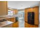 Kitchen with wood cabinets, black appliances, and hardwood floors at 5625 Chipola Cir, Orlando, FL 32839