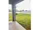 Covered patio overlooks a grassy backyard with a lake view at 420 Quarry Rock Cir, Kissimmee, FL 34758