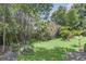 Mature, lush landscaping with a grassy area and stone firepit at 7904 Dunstable Cir, Orlando, FL 32817