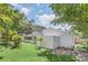 Spacious backyard with grassy area and mature trees surrounding home at 7904 Dunstable Cir, Orlando, FL 32817