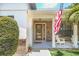 Brick front porch with a wooden door and American flag at 7904 Dunstable Cir, Orlando, FL 32817
