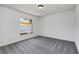 Bright bedroom with grey carpeting and large window at 7904 Dunstable Cir, Orlando, FL 32817