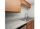 Kitchen with light wood cabinets, granite countertops, and a stainless steel sink at 301 Lewfield Cir, Winter Park, FL 32792