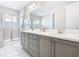 Elegant bathroom with double vanity, large mirror, and a walk-in shower at 7702 Graben St, Kissimmee, FL 34747
