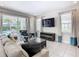 Living room with sliding doors to the backyard, and a large TV at 7702 Graben St, Kissimmee, FL 34747