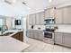 Modern kitchen with gray cabinets, stainless steel appliances, and an island at 7702 Graben St, Kissimmee, FL 34747