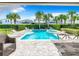 Inviting pool area with a spa, lounge chairs, and a wooden dining table at 7702 Graben St, Kissimmee, FL 34747