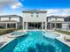 Relaxing pool and spa with lounge chairs, providing a perfect backyard oasis at 7702 Graben St, Kissimmee, FL 34747