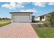 New construction home with a white garage door and brick paver driveway at 3645 Portsmouth Ln, Haines City, FL 33844