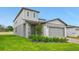 Two-story house with gray siding, brick paver driveway, and landscaping at 3669 Portsmouth Ln, Haines City, FL 33844