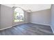 Bright living room featuring gray walls, vinyl plank flooring, and a large window at 7304 High Lake Dr, Orlando, FL 32818