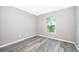 Simple bedroom with gray walls, vinyl plank flooring, and a window at 7304 High Lake Dr, Orlando, FL 32818