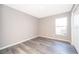Simple bedroom with gray walls, vinyl plank flooring, and a window at 7304 High Lake Dr, Orlando, FL 32818