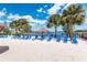 Relaxing beach area with lounge chairs and umbrellas near a lake at 514 Lucaya Loop # 514, Davenport, FL 33897
