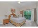 Bright bedroom with a queen-size bed, wood-look floors, and access to a balcony at 514 Lucaya Loop # 514, Davenport, FL 33897