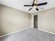 Bright bedroom with ceiling fan, window, closet, and neutral carpet at 11121 Sunup Ln, Orlando, FL 32825