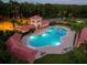 Night view of a resort-style community pool area with lush landscaping and lighting at 11121 Sunup Ln, Orlando, FL 32825