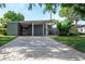 Mid-century modern home with a brick driveway and lush landscaping at 2148 Chippewa Trl, Maitland, FL 32751