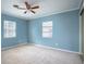 Spacious bedroom with two windows, ceiling fan, and light blue walls at 2148 Chippewa Trl, Maitland, FL 32751