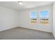 Bright bedroom with two windows, carpet, and neutral walls at 2462 Leeds St, Haines City, FL 33844
