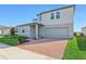 Two-story house with gray siding, brick driveway, and landscaping at 2462 Leeds St, Haines City, FL 33844
